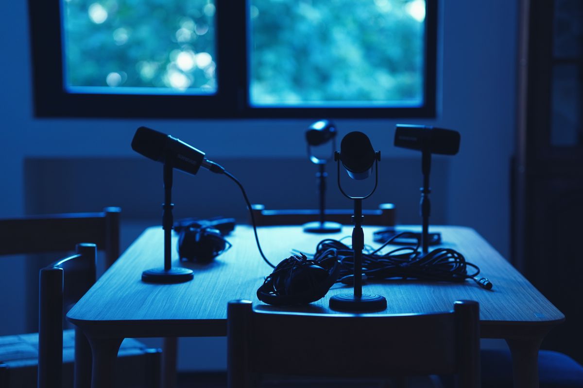 Plusieurs microphones professionnels installés sur une table dans un studio de podcast